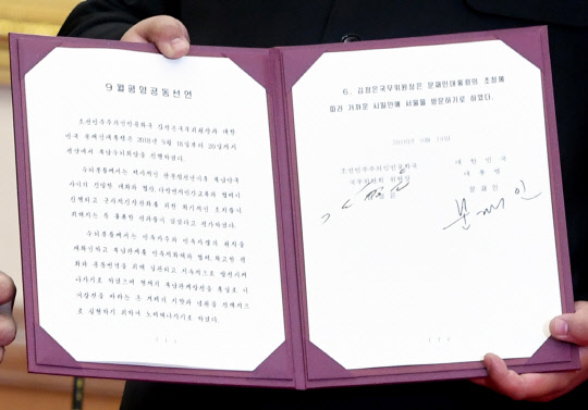 김정은 북한 국무위원장이 19일 백화원 영빈관에서 서명 뒤 펼쳐보인 9월 평양공동선언문.   연합뉴스